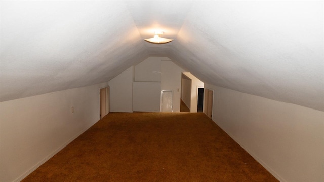 additional living space featuring lofted ceiling and carpet