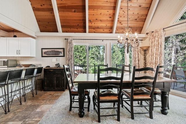 dining room with lofted ceiling with beams, light tile patterned floors, an inviting chandelier, and wooden ceiling