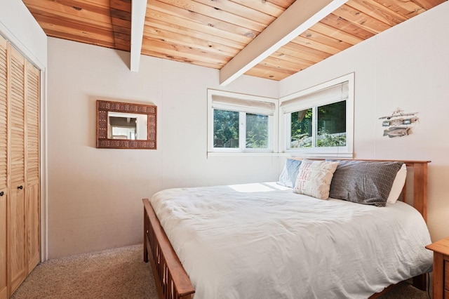 carpeted bedroom with wooden ceiling, beam ceiling, and a closet