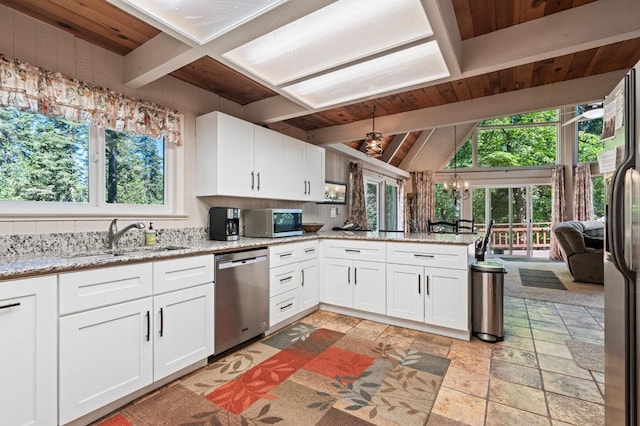 kitchen featuring beam ceiling, appliances with stainless steel finishes, wooden ceiling, sink, and kitchen peninsula