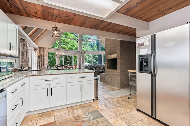 kitchen featuring appliances with stainless steel finishes, white cabinetry, wood ceiling, light tile patterned flooring, and a brick fireplace