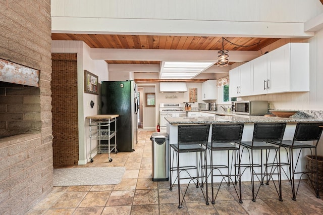 kitchen featuring wood ceiling, light stone countertops, light tile patterned floors, kitchen peninsula, and beamed ceiling