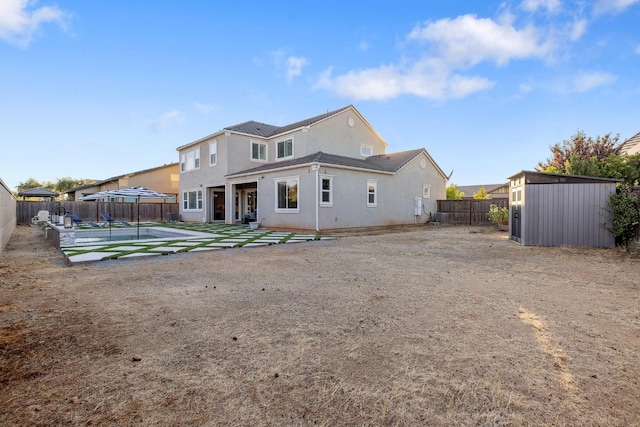 rear view of property featuring a storage shed