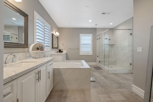 bathroom featuring vanity, a healthy amount of sunlight, and plus walk in shower