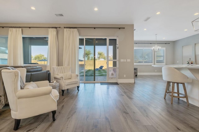 sitting room with hardwood / wood-style flooring and a chandelier