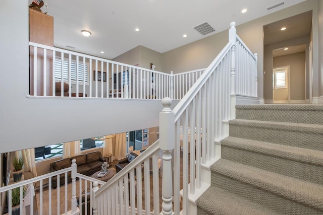 stairway with a wealth of natural light and carpet