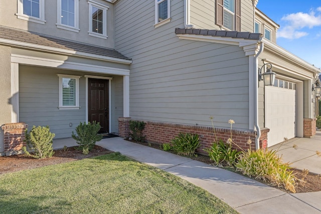 view of exterior entry with a yard