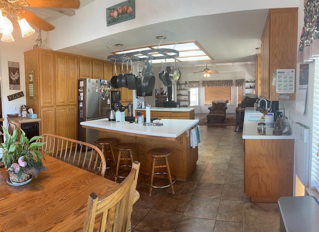 kitchen featuring sink, ceiling fan, kitchen peninsula, and stainless steel refrigerator