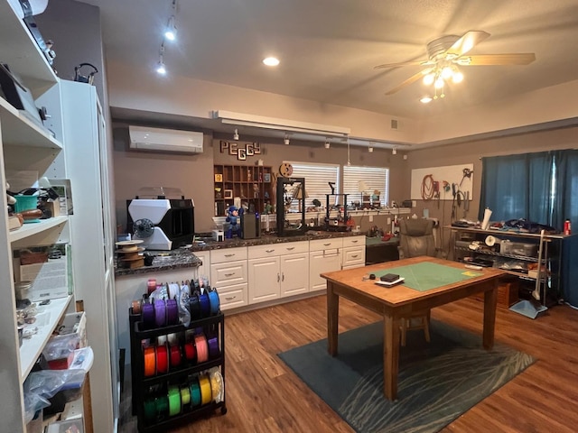 game room featuring light wood-type flooring, a wall unit AC, and ceiling fan