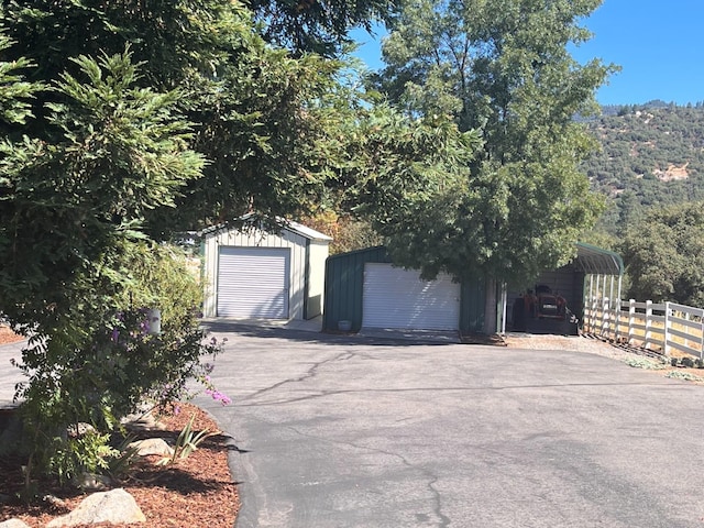 view of front of house with an outbuilding, a garage, a carport, and a mountain view