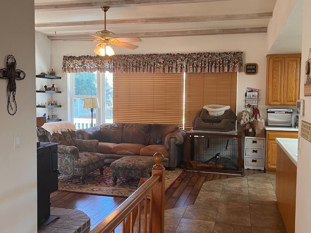 living room with hardwood / wood-style floors, ceiling fan, and beamed ceiling