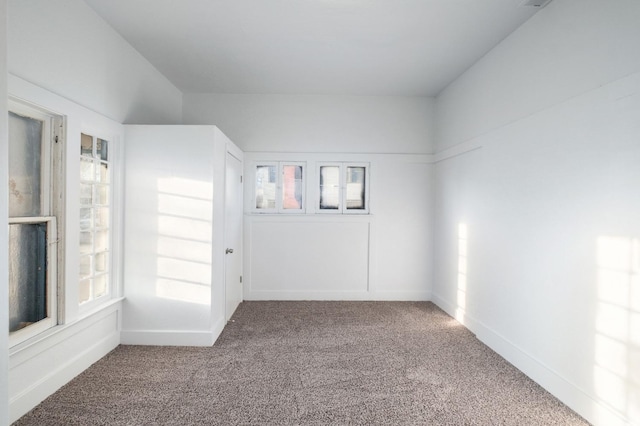 carpeted spare room featuring baseboards