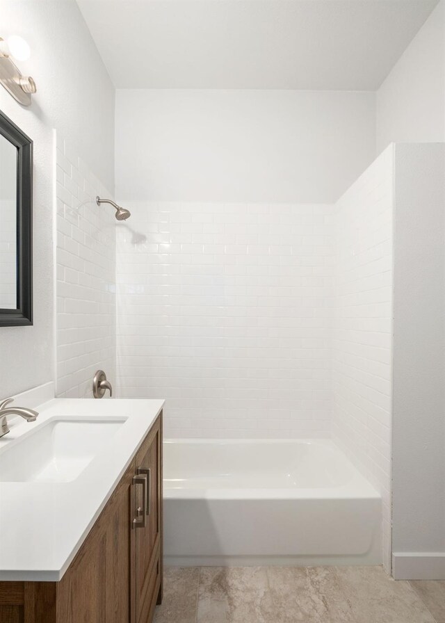 bathroom with tiled shower / bath combo, tile patterned floors, and vanity