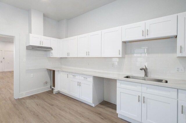 kitchen featuring backsplash, light hardwood / wood-style flooring, and sink