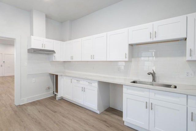 kitchen with white cabinets, a sink, and light wood finished floors