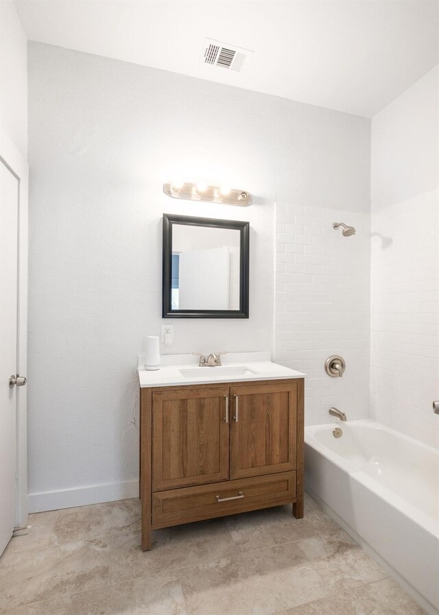 bathroom featuring tile patterned floors, vanity, and tiled shower / bath