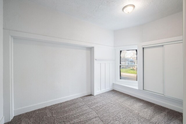 carpeted spare room featuring a textured ceiling