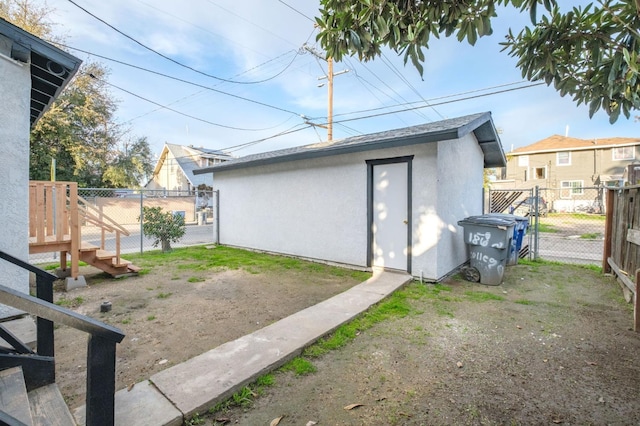 view of outbuilding featuring fence and an outbuilding