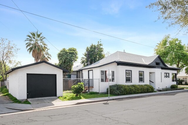 view of front of home featuring a garage and an outbuilding