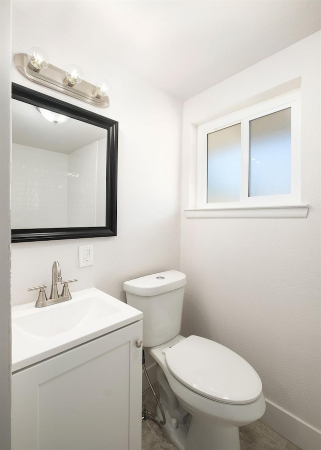 bathroom featuring tile patterned flooring, vanity, and toilet