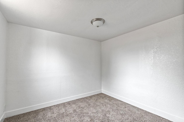 empty room featuring carpet and a textured ceiling