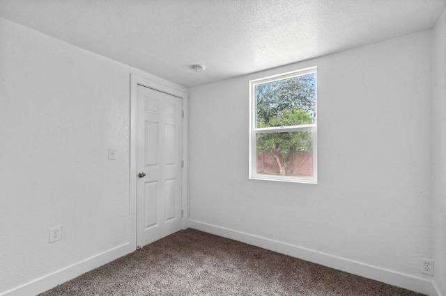 unfurnished room featuring carpet and a textured ceiling