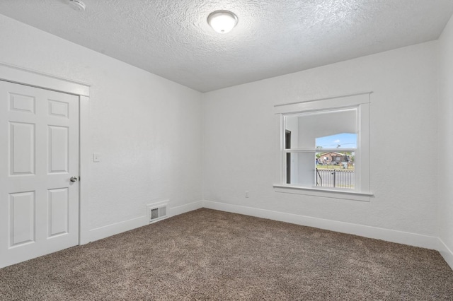 carpeted spare room with a textured ceiling