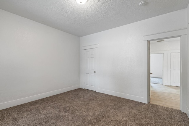 spare room featuring carpet flooring and a textured ceiling