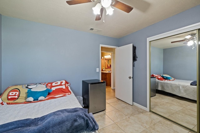 bedroom featuring ceiling fan, a textured ceiling, and light tile patterned floors