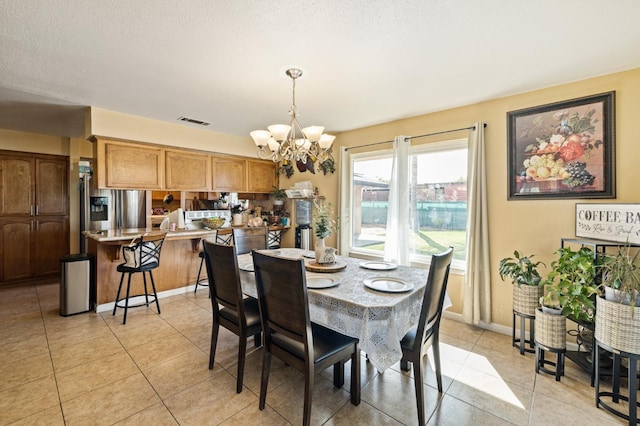 dining area featuring light tile patterned flooring and a chandelier