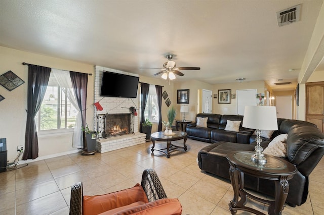 tiled living room with a brick fireplace and ceiling fan