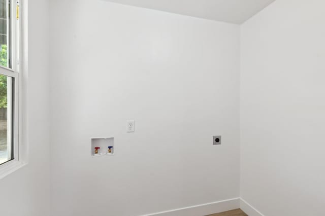 laundry area featuring hookup for a washing machine, electric dryer hookup, wood finished floors, laundry area, and baseboards