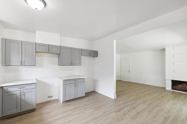 kitchen featuring light countertops, light wood finished floors, and gray cabinets