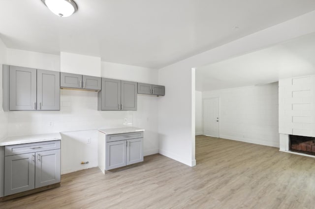 2546 E Pontiac Way, Fresno, CA 93726 - kitchen with gray cabinets, light wood-type flooring, a fireplace, and baseboards