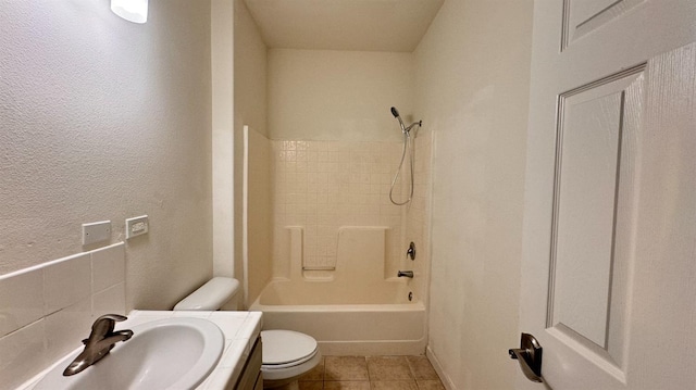 full bathroom with tiled shower / bath, toilet, tile patterned floors, and vanity