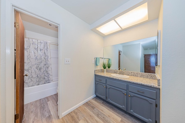 full bathroom with shower / bath combo with shower curtain, toilet, vanity, and hardwood / wood-style flooring