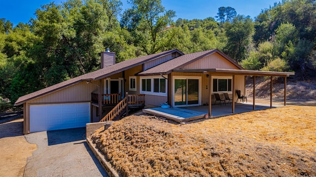 view of front facade featuring a patio, a garage, and a deck