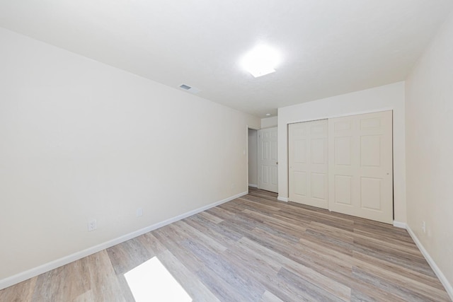 unfurnished bedroom featuring a closet and light wood-type flooring