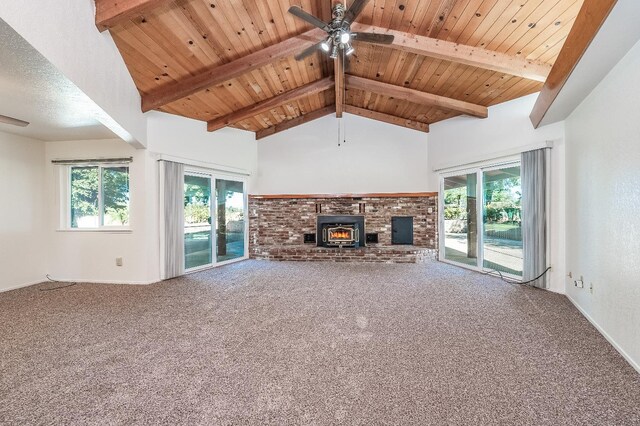 unfurnished living room featuring beam ceiling, carpet, a fireplace, ceiling fan, and wooden ceiling