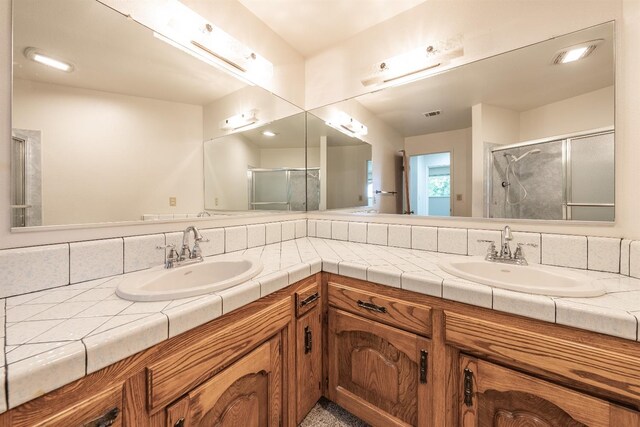 bathroom featuring decorative backsplash, vanity, and walk in shower