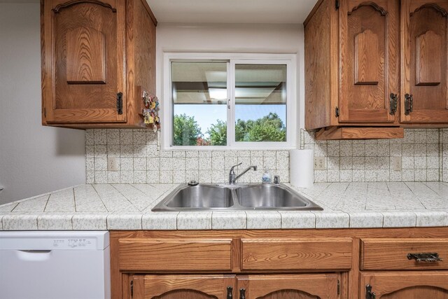 kitchen featuring sink, dishwasher, and tasteful backsplash