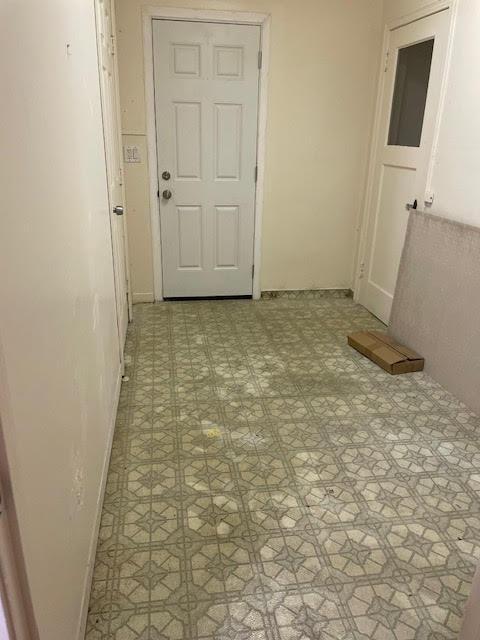 hall with tile patterned floors