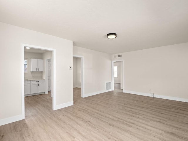 spare room with light hardwood / wood-style floors and a healthy amount of sunlight