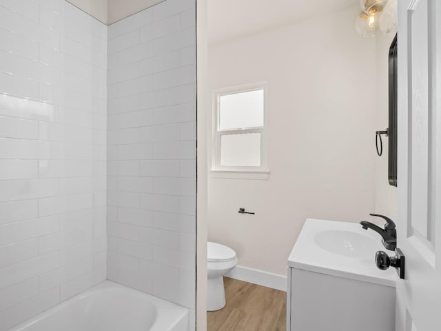 full bathroom featuring tiled shower / bath combo, wood-type flooring, toilet, and vanity