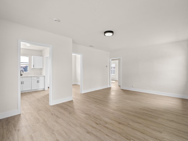 unfurnished room featuring sink and light hardwood / wood-style floors