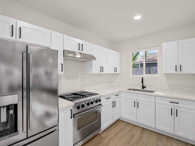 kitchen with sink, stainless steel appliances, light hardwood / wood-style floors, and white cabinets