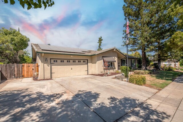 ranch-style house with solar panels and a garage