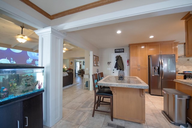 kitchen with a breakfast bar, stainless steel appliances, tasteful backsplash, light countertops, and a kitchen island