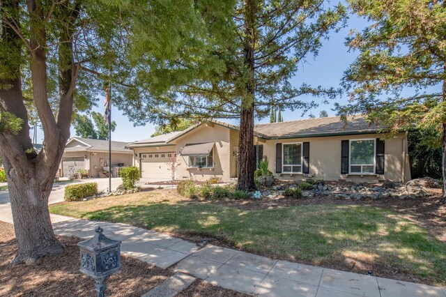 ranch-style house with a garage and a front yard