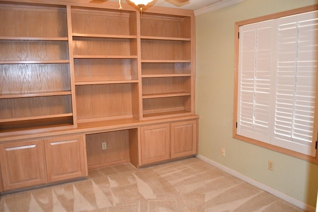 unfurnished office featuring ceiling fan, crown molding, and light carpet